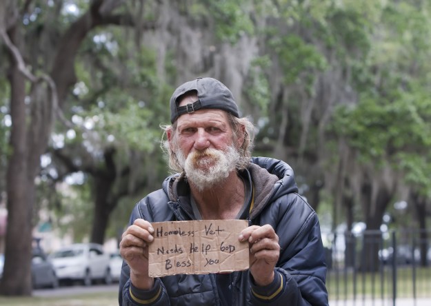 Homeless man holding sign