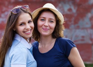 Young smiling woman with her teen daughter
