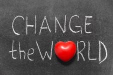 change the world phrase handwritten on blackboard with heart symbol instead of O