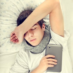 Toned Photo of Tired Young Man sleep with Tablet Computer on the Bed