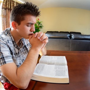 Teenager having daily devotional at home. Christian lifestyle. Peace and love while praying